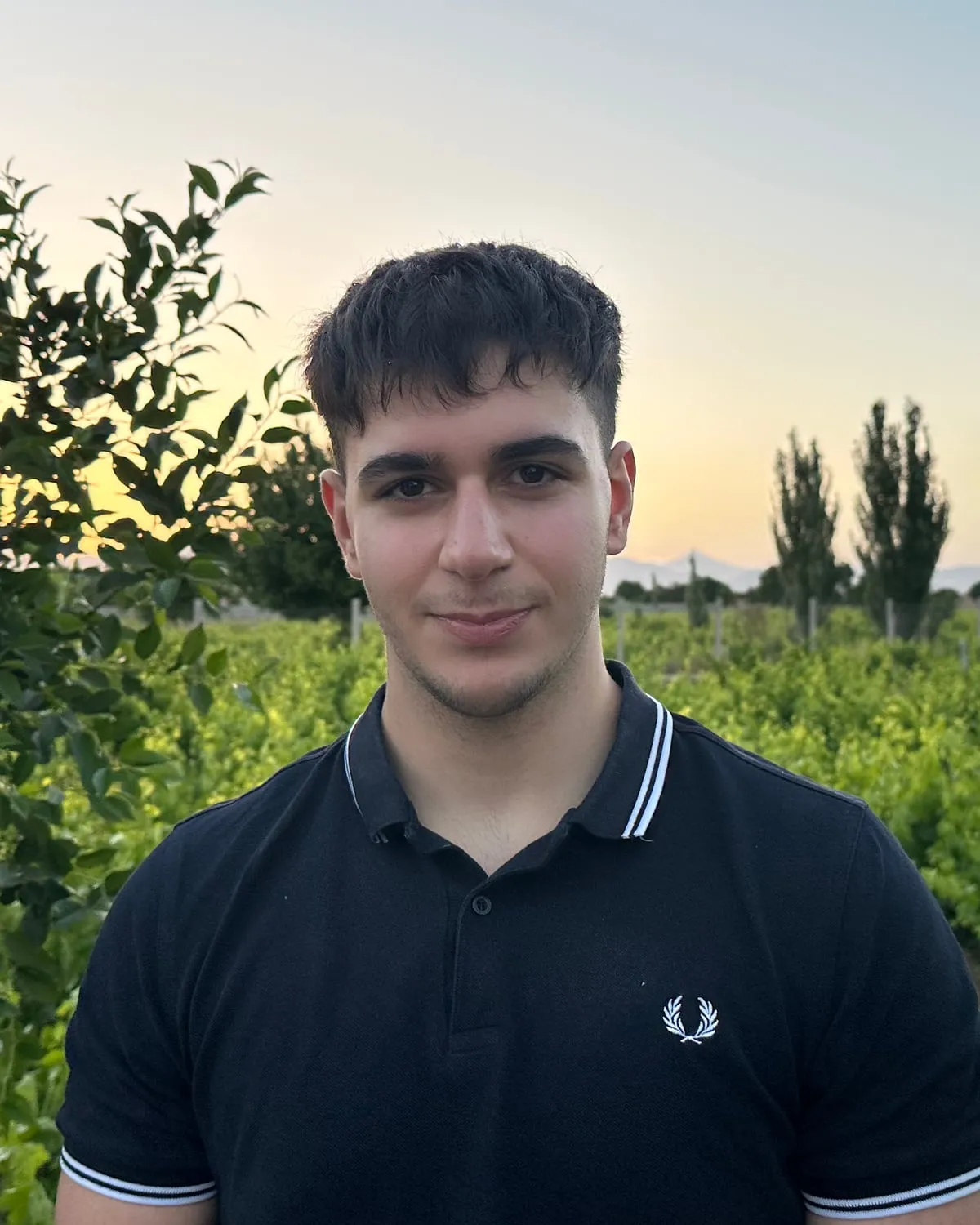 Benjamin, who runs Nightshift AI, standing in a vineyard at sunset